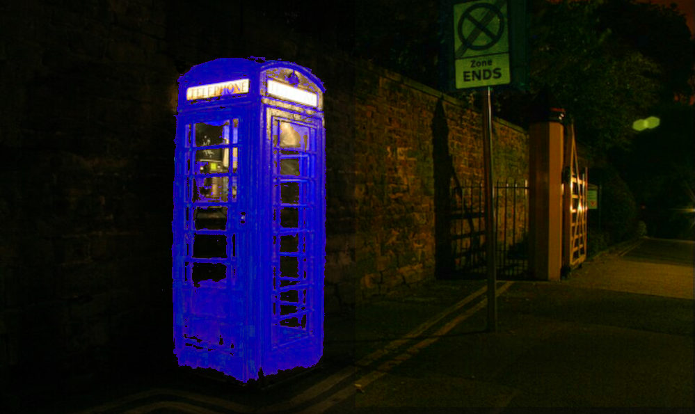 A traditional red telephone box, of the kind once common in the UK, now shrouded in darkness. Nearby, a sign says 'Zone Ends'. Through image manipulation, the telephone box's normal colour of red is now blue, in the best Tardis traditions. Original image - Wikimedia Commons. Used and modified under the terms of the Creative Commons Attribution-Share Alike 2.0 license.